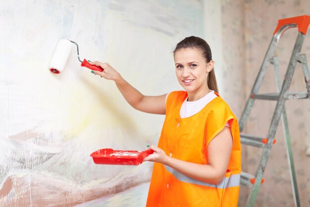 housepainter paints wall with roller