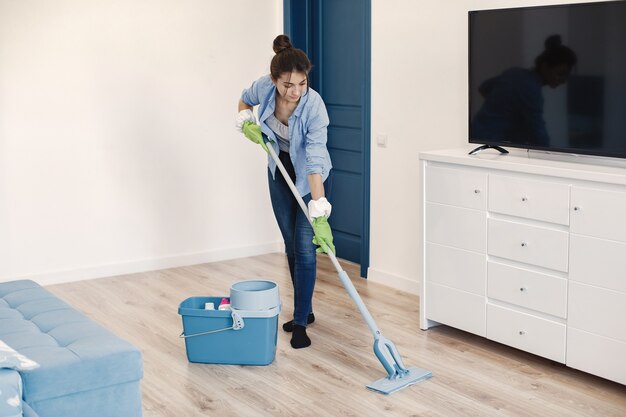 Casalinga che si sveglia a casa. signora in una camicia blu. pavimento pulito della donna.