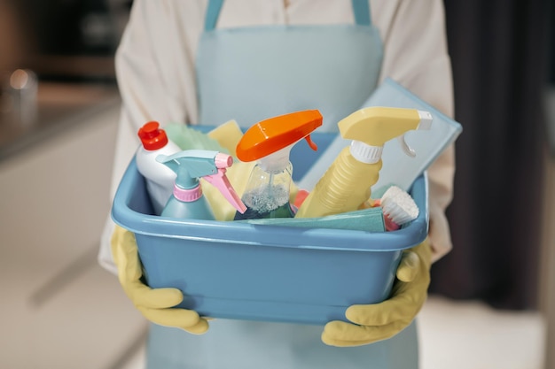 Housewife. Young smiling woman with a basin with cleansing appliances