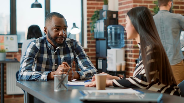 HR employee greeting job seeker to talk about work recruitment, interviewing candidate at work application meeting. Woman having conversation with man about company employment.