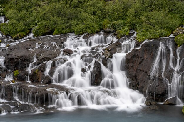 Hraunfossar waterfalls surrounded by greenery at daytime in Iceland