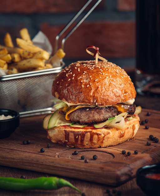 Huge burger with fried meat and vegetables