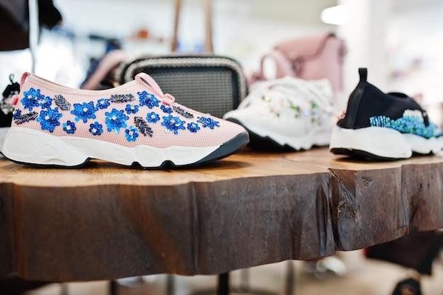 Huge variety of female shoes and bags of different colors on the shelves of the shop