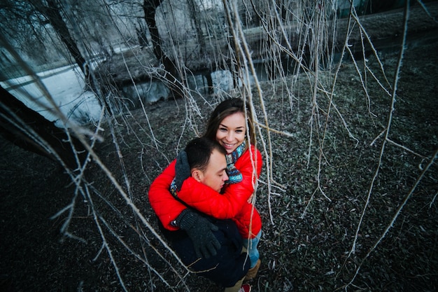 Hugged couple seen among the branches of a tree