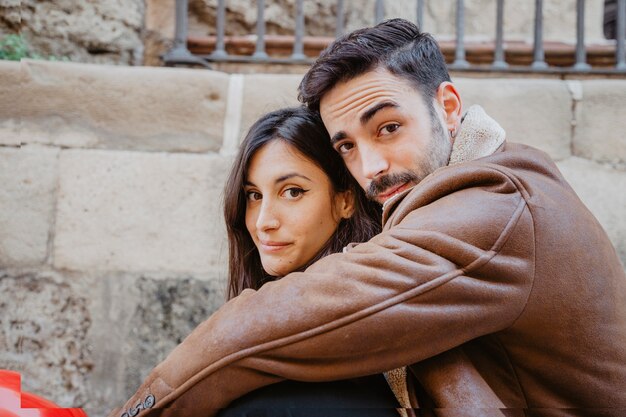 Hugging couple looking at camera