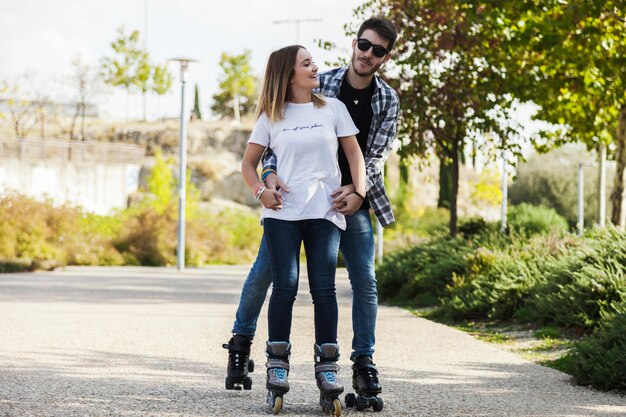 Hugging couple riding roller skates