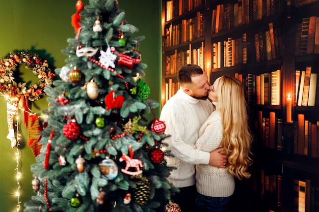 Free photo hugging couple stands before a christmas tree