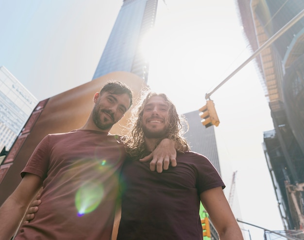 Hugging friends outdoor in sunlight