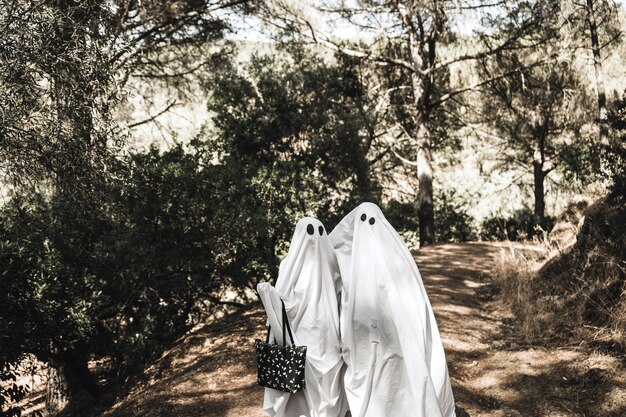 Hugging ghosts standing in park