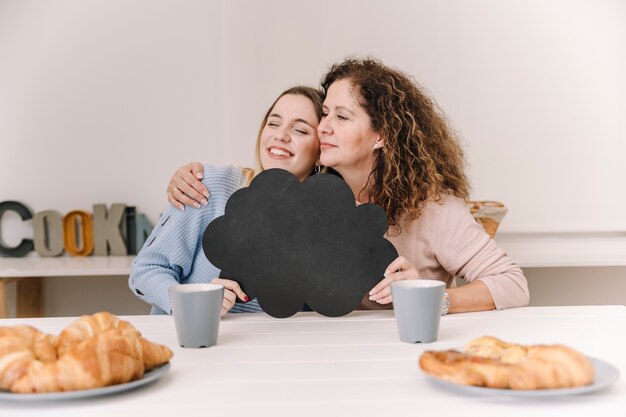 Hugging mother and daughter with speech balloon