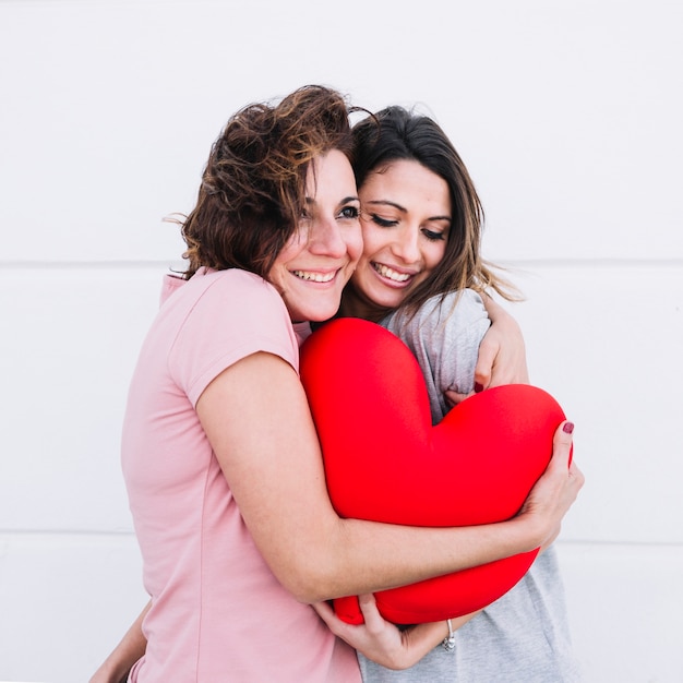 Foto gratuita abbracciare le donne con il cuore del giocattolo