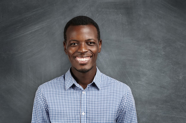 Human face expressions, emotions and feelings. Portrait of joyful African employee smiling with his white teeth, happy with big promotion and career growth. Success and achievements.