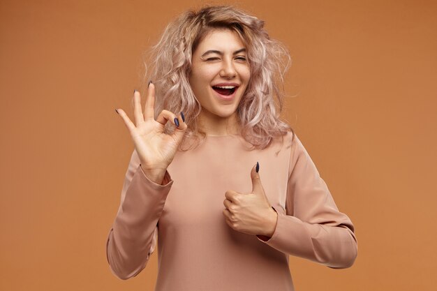 human facial expressions and body language. horizontal of stylish fashionable young caucasian female with messy pinkish hair exclaiming with excitement
