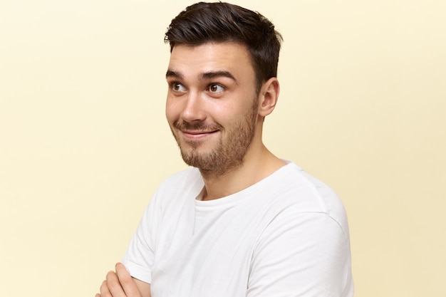 Human facial expressions, emotions and feelings. Emotional attractive young male raising his eyebrows surprised with astonishing news.