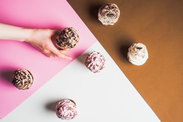 Human hand grabbing fresh tasty muffin