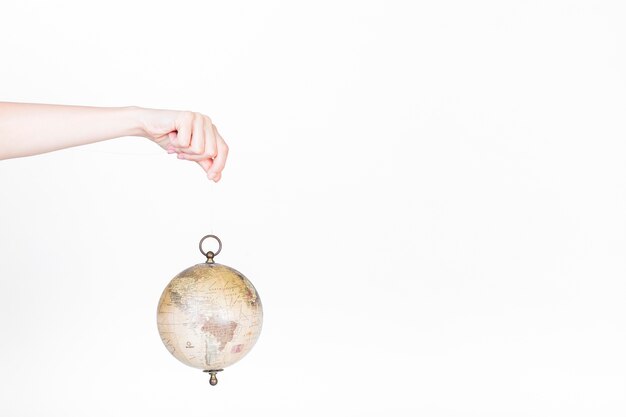 Human hand holding globe pendulum