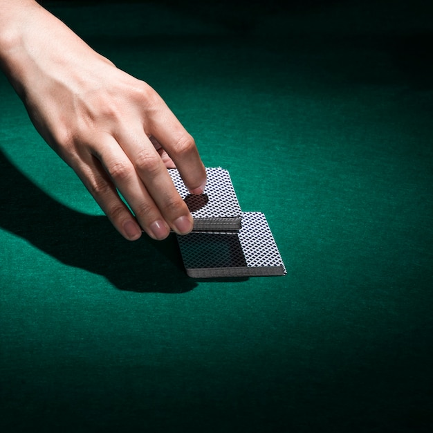 Human hand holding poker card in casino