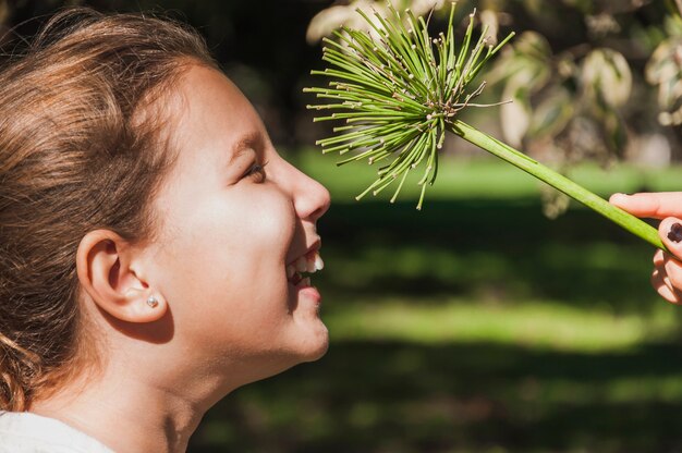 Free photo human hand holding stem in front of happy girl's face