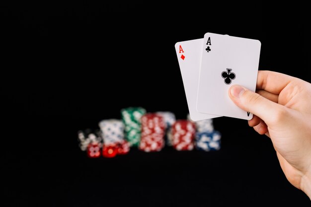 Человеческая рука, состоящая из двух тузов игральных карт