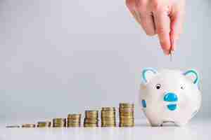 Free photo human hand inserting coin in piggybank