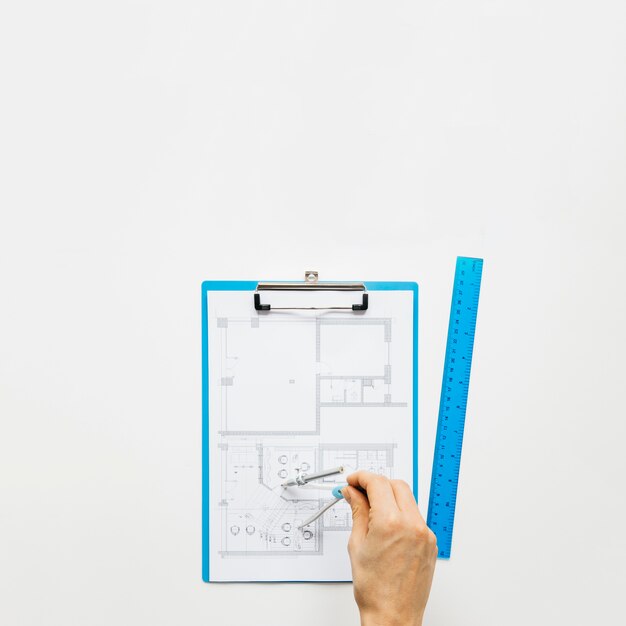 human hand making blueprint using rounder on white desk