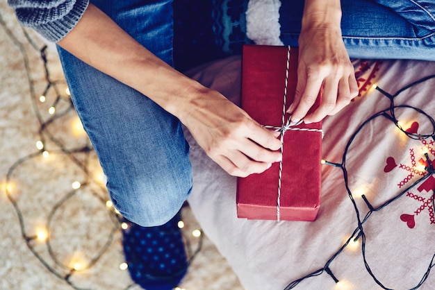 Human hand tying a string on a gift 
