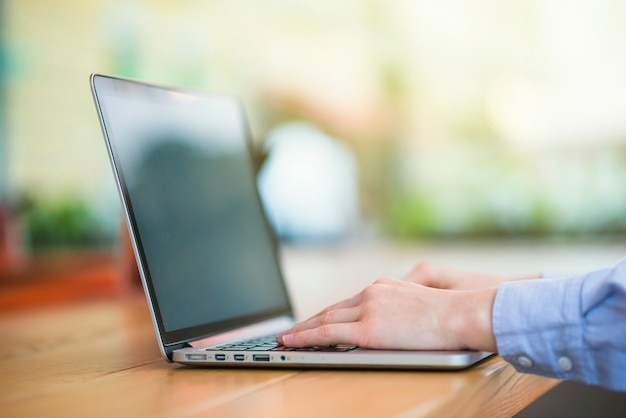 Human hand typing on laptop keypad