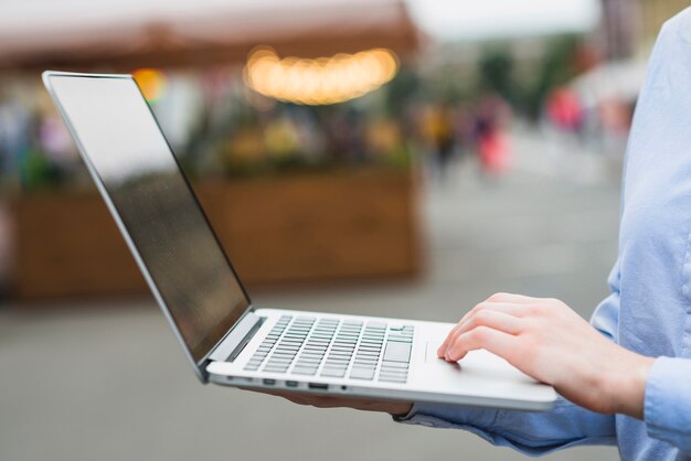 Human hand using laptop at outdoors