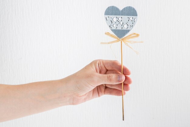 Human hand with ornament heart on wand