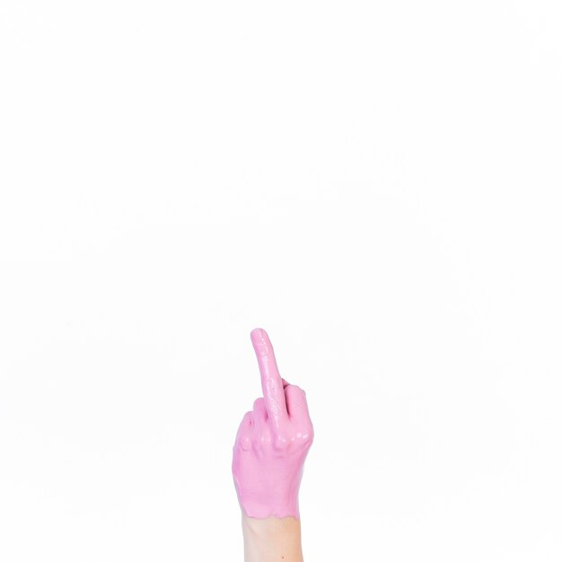 Рука человека с розовой краской, показывающая средний палец