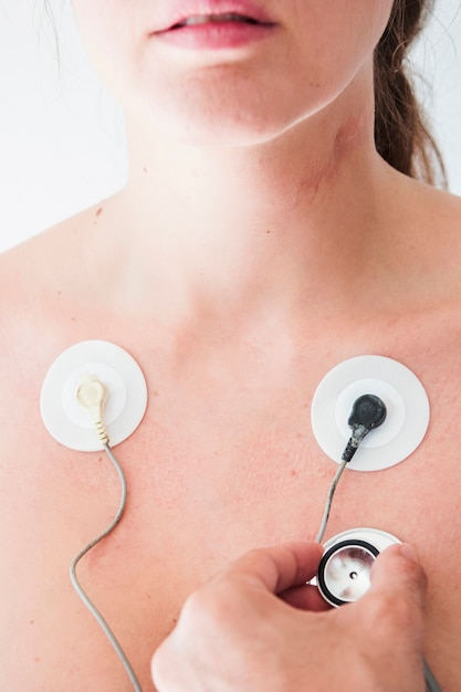 Human hand with stethoscope checking respiration of woman