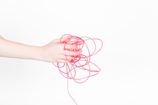 Human hand with tangled red wire