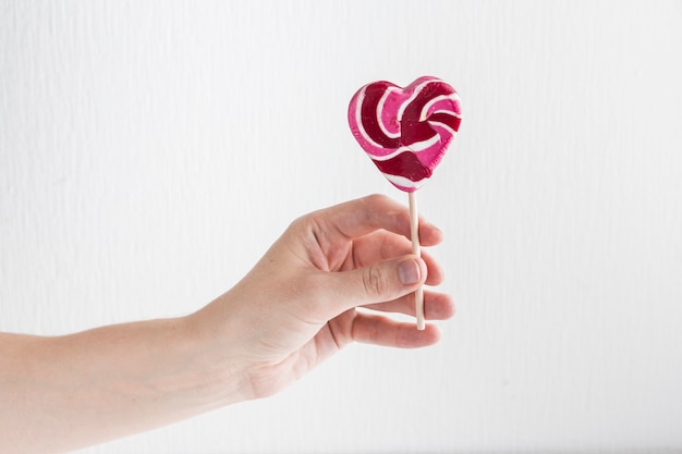 Human hand with tasty lollipop 