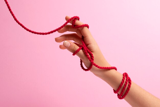赤い糸でつながれた人間の手