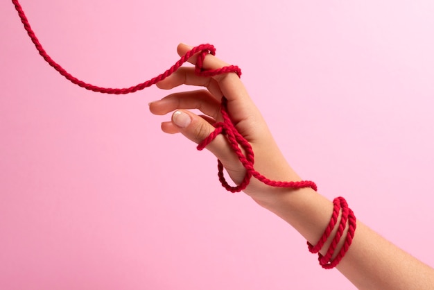 Human hands connected with red thread