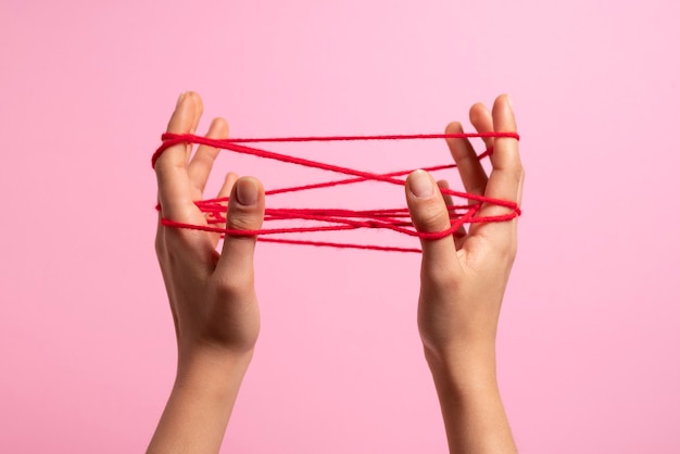 Human hands connected with red thread