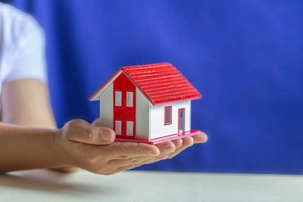 Free photo human hands holding model of dream house