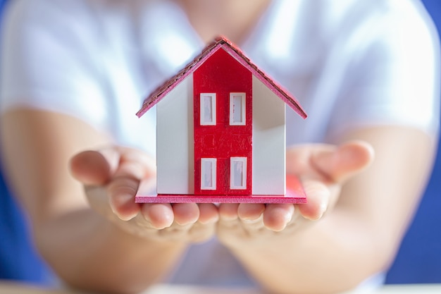 Human hands holding model of dream house