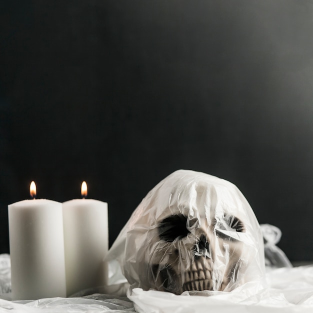 Human skull in plastic bag and candles