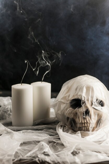 Human skull in plastic bag with white candles