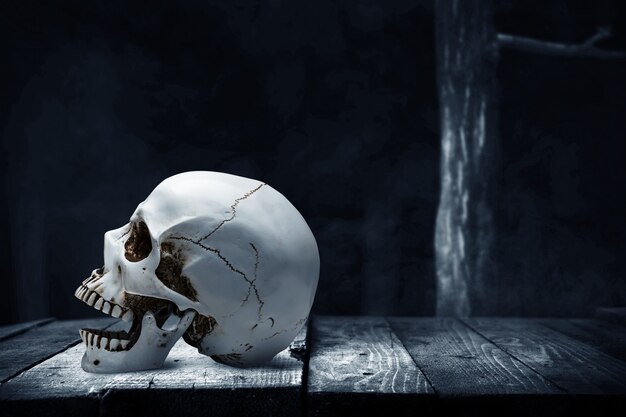 어두운 배경으로 나무 테이블에 인간의 두개골