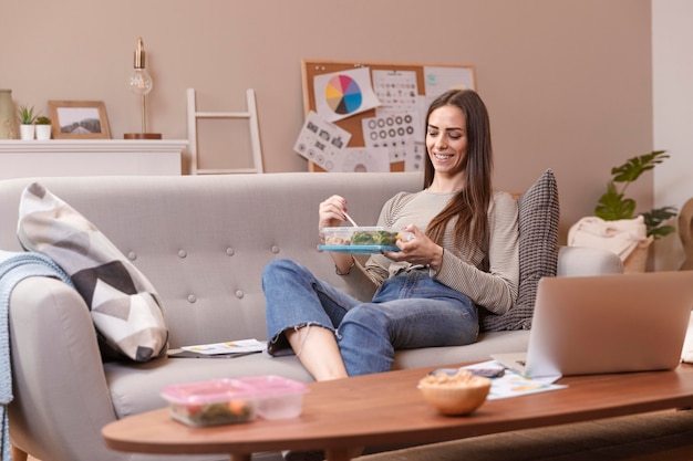 Hungry businesswoman eating long shot