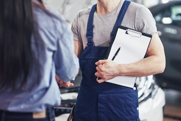 husband car mechanic and woman customer make an agreement on the repair of the car