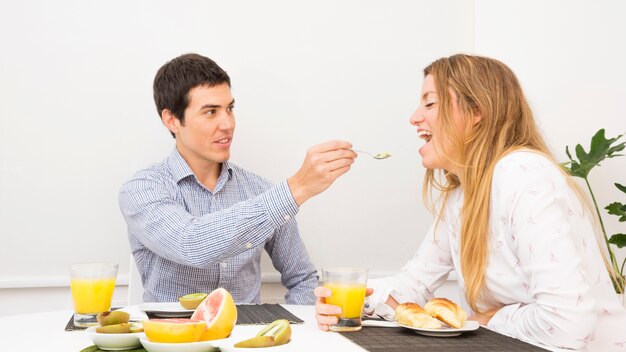 남편이 아침을 먹고 그녀의 여자 친구에게 음식을 먹이