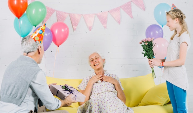 Husband and granddaughter celebrating woman's birthday