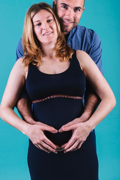 Free photo husband hugging pregnant woman