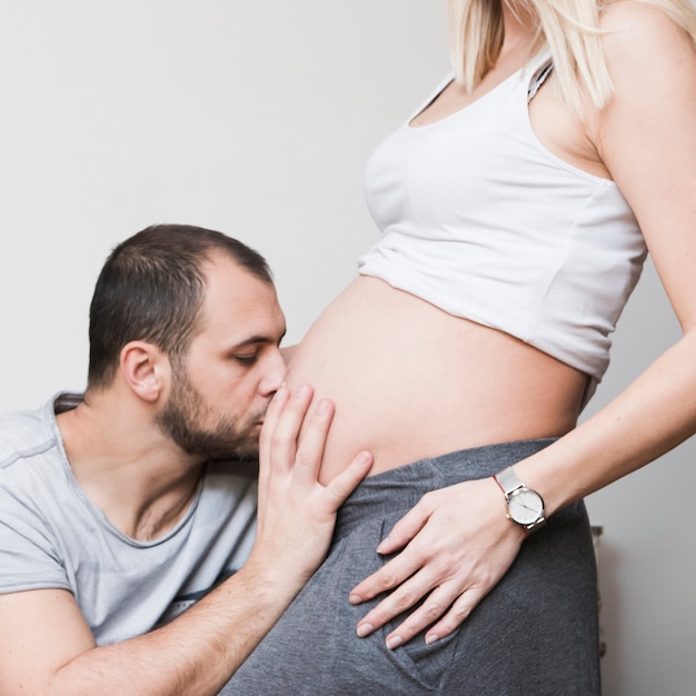 Муж целует беременную женщину