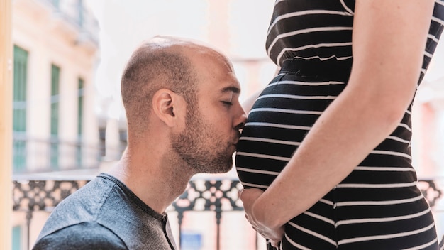 Foto gratuita marito che bacia donna incinta