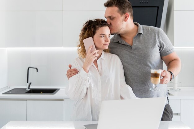 Free photo husband kissing wife on head