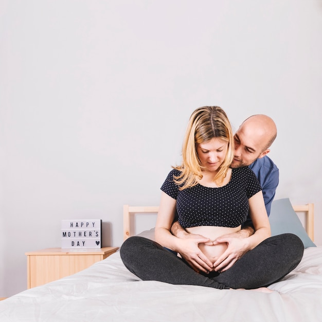 Free photo husband sitting behind pregnant woman